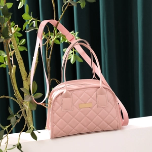 Detailed view of pink quilted PU leather handbag with gold plaque and fabric shoulder strap