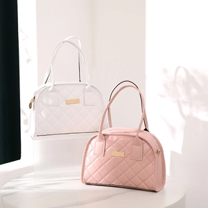 Quilted crossbody bags in white and pink with elegant gold hardware on pedestals