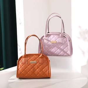 Detail of quilted leather handbags in brown and lavender with gold hardware