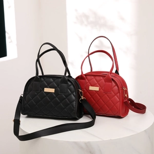 Close-up of black and red quilted handbags with gold hardware on white display stands
