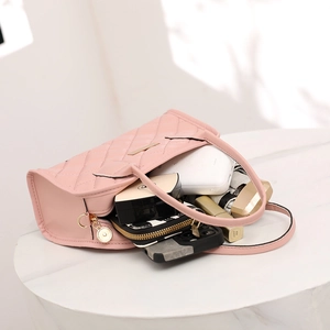 Spacious interior of pink quilted handbag showing daily essentials and golden zipper detail