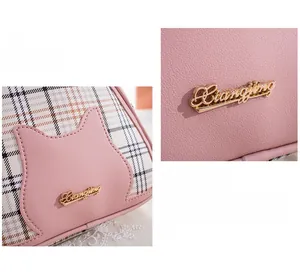 Detail of pink plaid shell bag featuring cat-shaped leather patch and golden logo