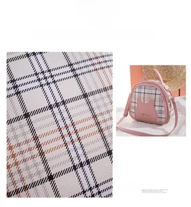Close-up of pink plaid crossbody bag featuring cat ear design and premium metal logo