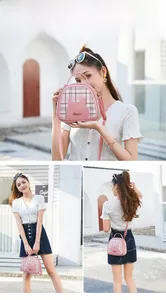 Detail of pink plaid crossbody bag with cute cat patch and golden logo for women