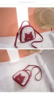 Detail showing red plaid shell bag with cute cat patch and golden metal logo