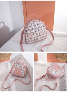 Detailed view of pink plaid handbag with cat-shaped pocket and golden hardware