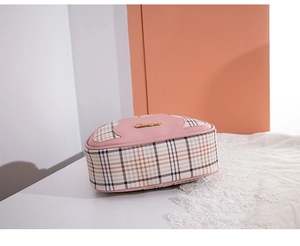 Detail of pink plaid crossbody shell bag featuring golden cursive metal logo and leather trim