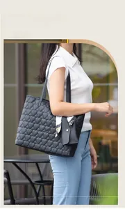 Detail of black heart quilted tote bag with matching pouch and stylish printed silk scarf