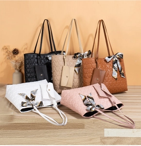 Detail of five heart-quilted leather tote bags with silk scarves and matching mini pouches