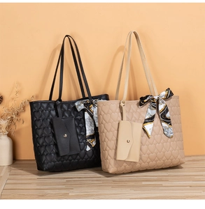 Detail of embroidered heart quilted tote bags with elegant silk scarves and matching pouches