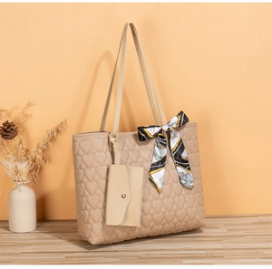 Detail of beige quilted heart tote bag with small pouch and bohemian silk scarf handle
