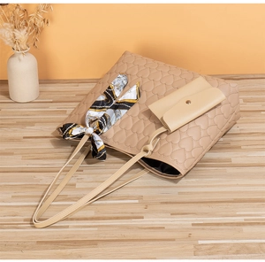 Detail view of heart-quilted tote bag with printed silk scarf on wooden surface