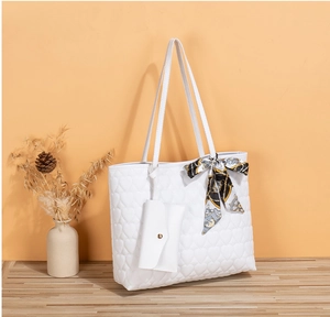 Detail of white heart-quilted tote bag with decorative floral silk scarf and coin purse