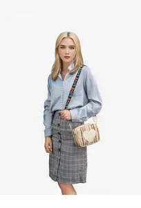 Close-up of woven crossbody bag featuring a large heart patch and colorful LOVE strap