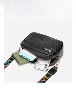 Interior view showing the large capacity of a black quilted crossbody bag with essentials