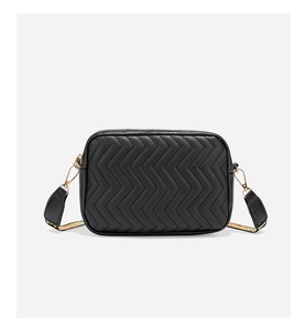 Detail of black crossbody camera bag with V-shaped quilting and wide floral woven strap