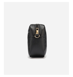 Side view of black quilted leather camera bag featuring golden metal zipper and D-ring