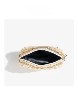 Detailed top view of beige woven phone bag interior with golden zipper and black lining