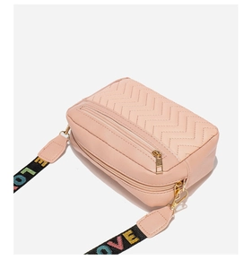 Close-up of pink quilted crossbody bag with wide colorful LOVE embroidered strap