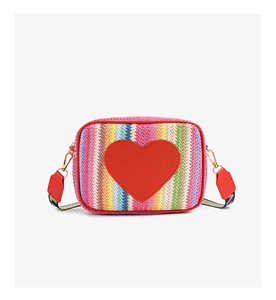 Macro shot of rainbow woven texture and red heart patch detail on mini crossbody bag