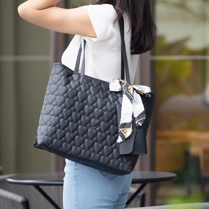 Quilted heart tote bag with silk scarf and detachable pouch shown on model in street setting
