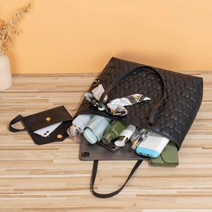 Black heart-quilted tote bag set with matching pouch and daily essentials inside
