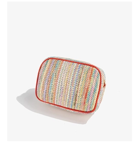 Macro detail of colorful woven texture and red leather trim on crossbody phone bag