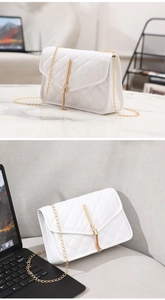 Close-up of a white quilted chain crossbody bag featuring a golden tassel metal clasp