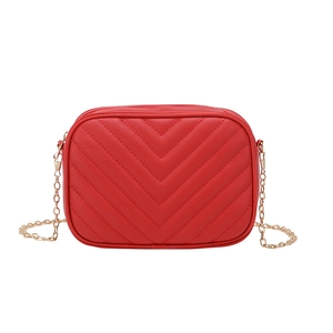 Red crossbody camera bag with chevron quilting and golden chain strap on white background
