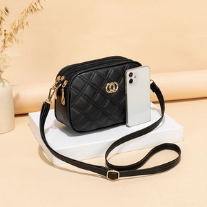 Black quilted crossbody bag with triple zipper compartments and gold ring hardware