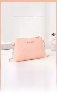 Détail du sac à bandoulière matelassé rose avec chaîne dorée et logo métallique
