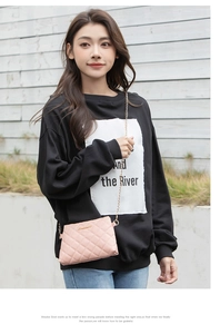 Vue détaillée du sac à bandoulière rose matelassé avec chaîne dorée sur mannequin femme