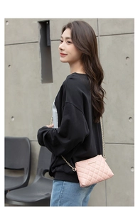 Détail du sac bandoulière en cuir PU rose matelassé avec chaîne dorée et logo métal