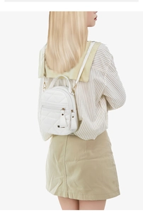 Détail d'un mini sac à dos blanc matelassé avec pompons en cuir et détails dorés