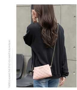 Vue arrière d'un mannequin portant un sac à bandoulière matelassé rose avec chaîne dorée