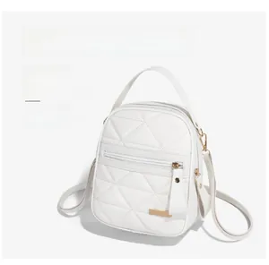 Détail du mini sac à dos matelassé blanc montrant les finitions dorées et l'anse