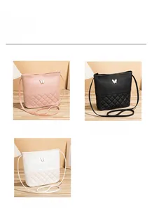 Détail de sacs bandoulière en similicuir matelassé rose, noir et blanc avec petit papillon