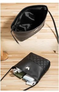 Vue détaillée de l'intérieur du sac matelassé noir montrant les compartiments de rangement
