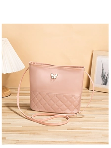 Détail du sac bandoulière matelassé rose avec boucle décorative papillon élégante