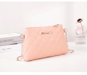 Gros plan du sac à bandoulière matelassé rose avec motif losange et chaîne dorée