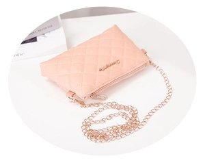 Détail du sac bandoulière matelassé orange-rose avec chaîne dorée et logo en métal