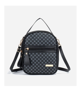 Gros plan du motif géométrique sur le sac à bandoulière en cuir noir avec boucles d'or