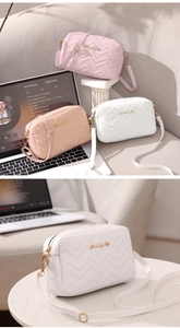Three quilted crossbody bags in white, pink and apricot displayed on a modern stylish desk