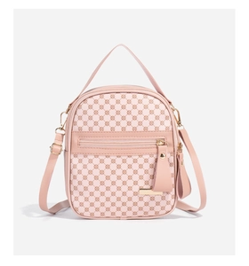 Vue détaillée du sac à dos rose à motif floral avec plaque logo dorée et bandoulière