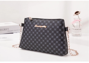 Détail du sac bandoulière gris avec motif floral géométrique et logo en métal doré