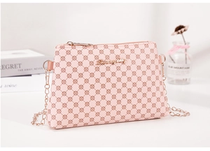 Gros plan du sac rose avec motif monogramme trèfle et détails métalliques dorés