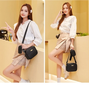 Detail of black quilted crossbody bag set with detachable round mini coin pouch and gold logo