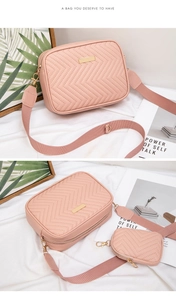 Close-up of pink V-quilted crossbody bag with mini coin purse and wide fabric strap