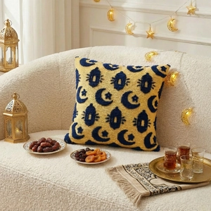 Yellow Eid Ramadan cushion cover with blue tufted moon and lantern motifs on a sofa