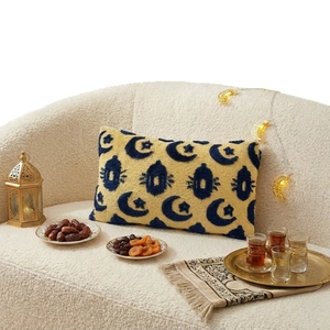 Rectangular tufted Ramadan pillow with yellow moon and blue lantern pattern on sofa
